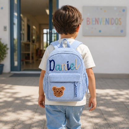 Niño de espaldas con la mochila en el cole